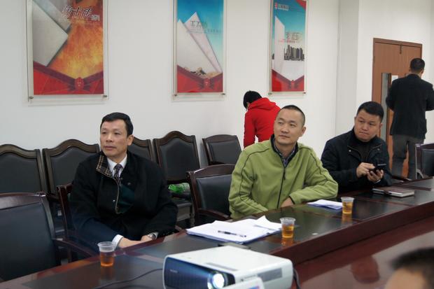 图6、寓目幻灯片的同时，，，，，，，，hjc888黄金城仿古砖副总曹坚贞（右一）特殊用手机记下专卖店装修效果的差别亮点